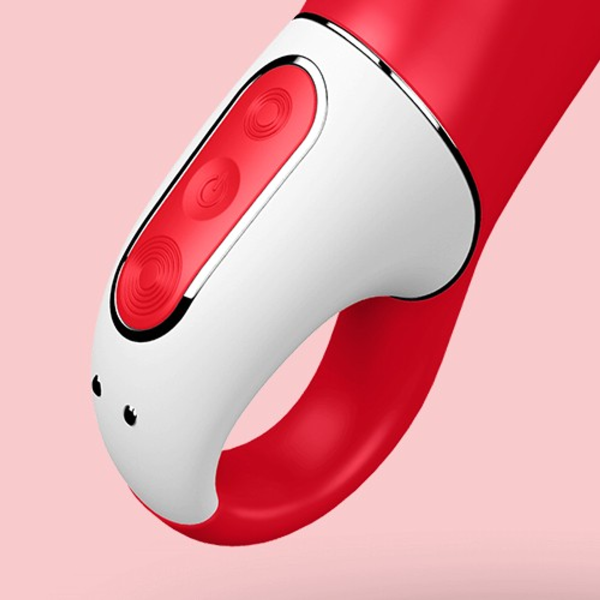 Czerwona i biała zabawka erotyczna z przyciskami i uchwytem w kształcie pierścienia, na różowym tle.