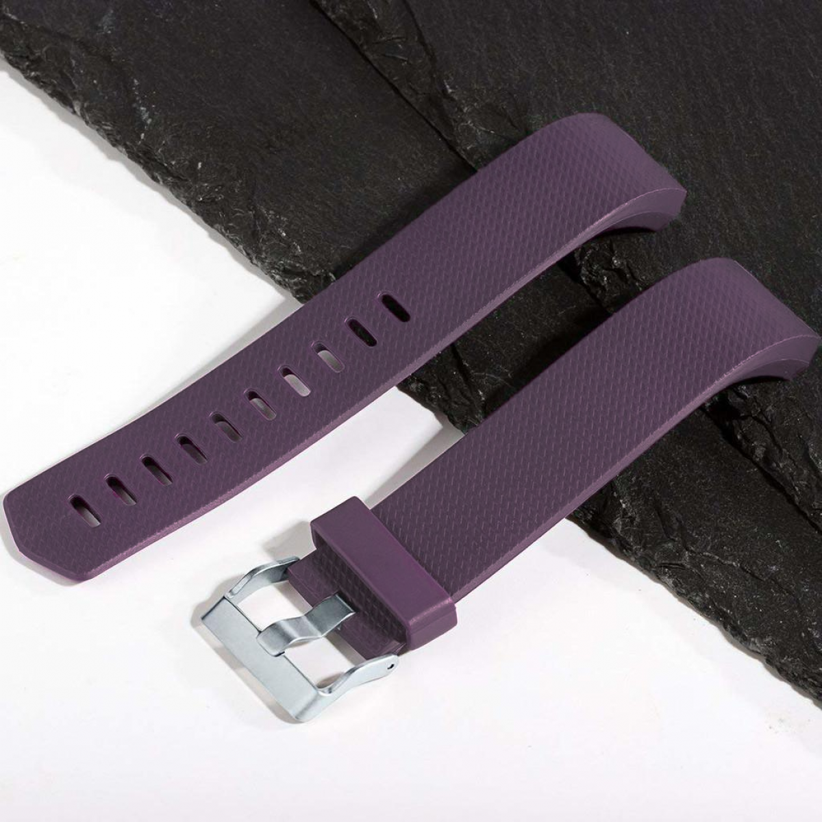 Correas de reloj moradas. Una tiene agujeros, la otra una hebilla.