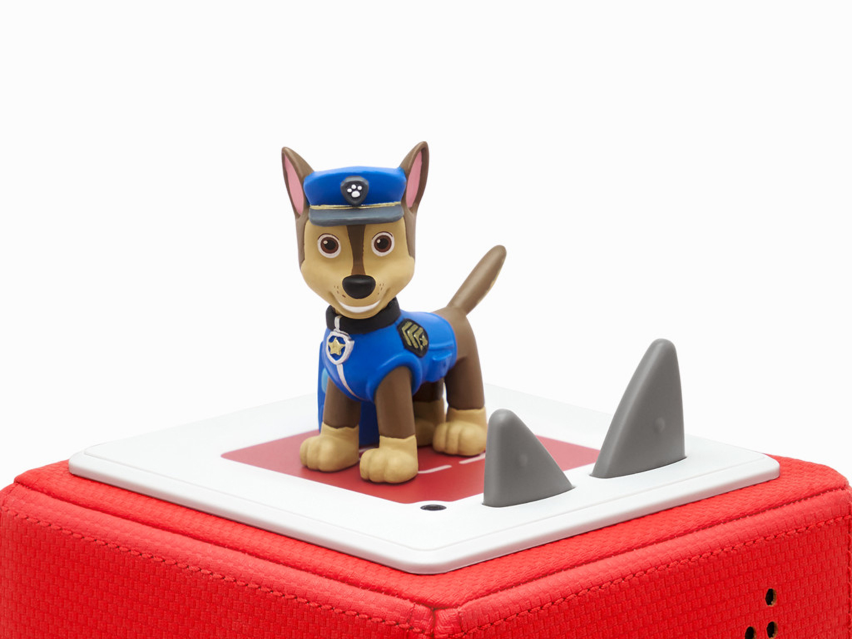 Chase von Paw Patrol Spielzeug auf roter Basis mit grauen Haifischflossen.