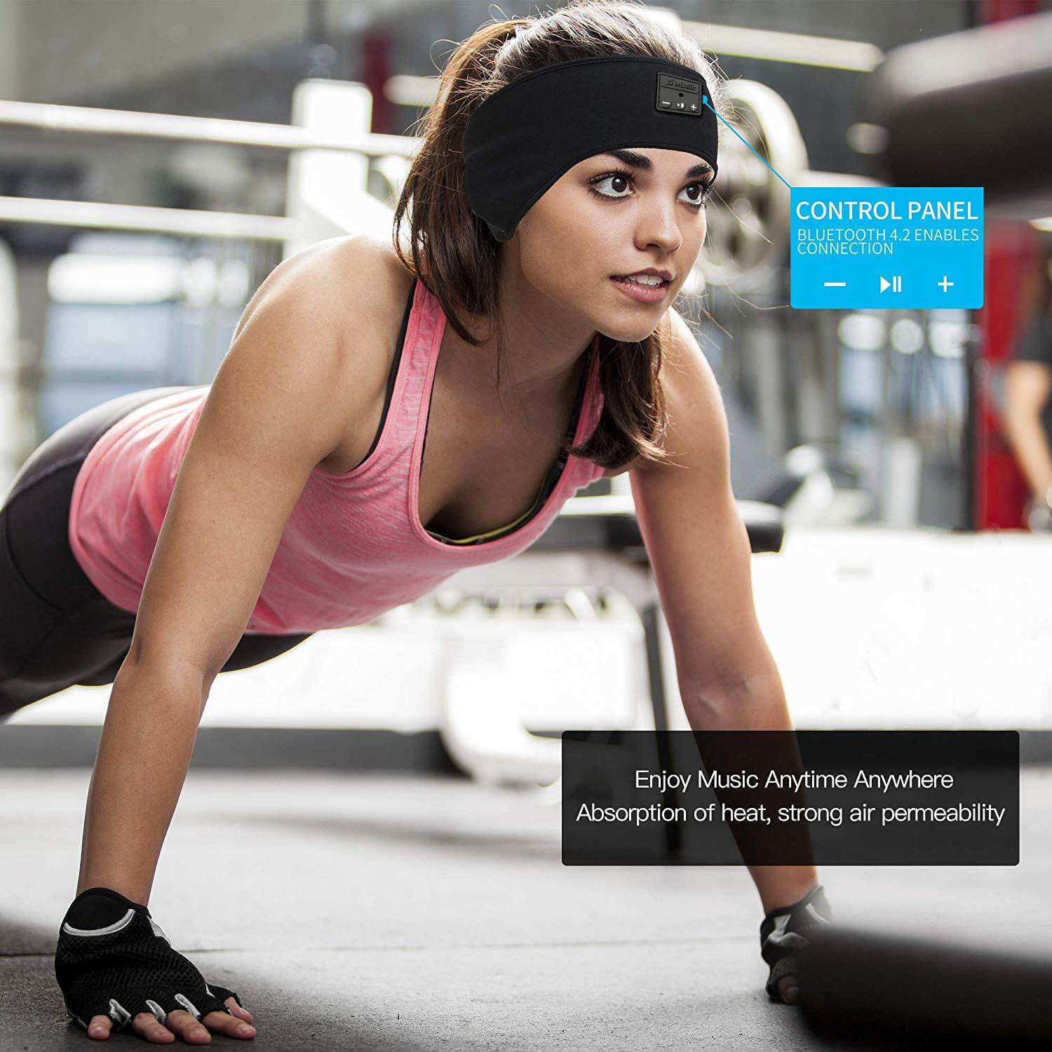 Kobieta robi pompki na siłowni w czarnej opasce z słuchawkami.