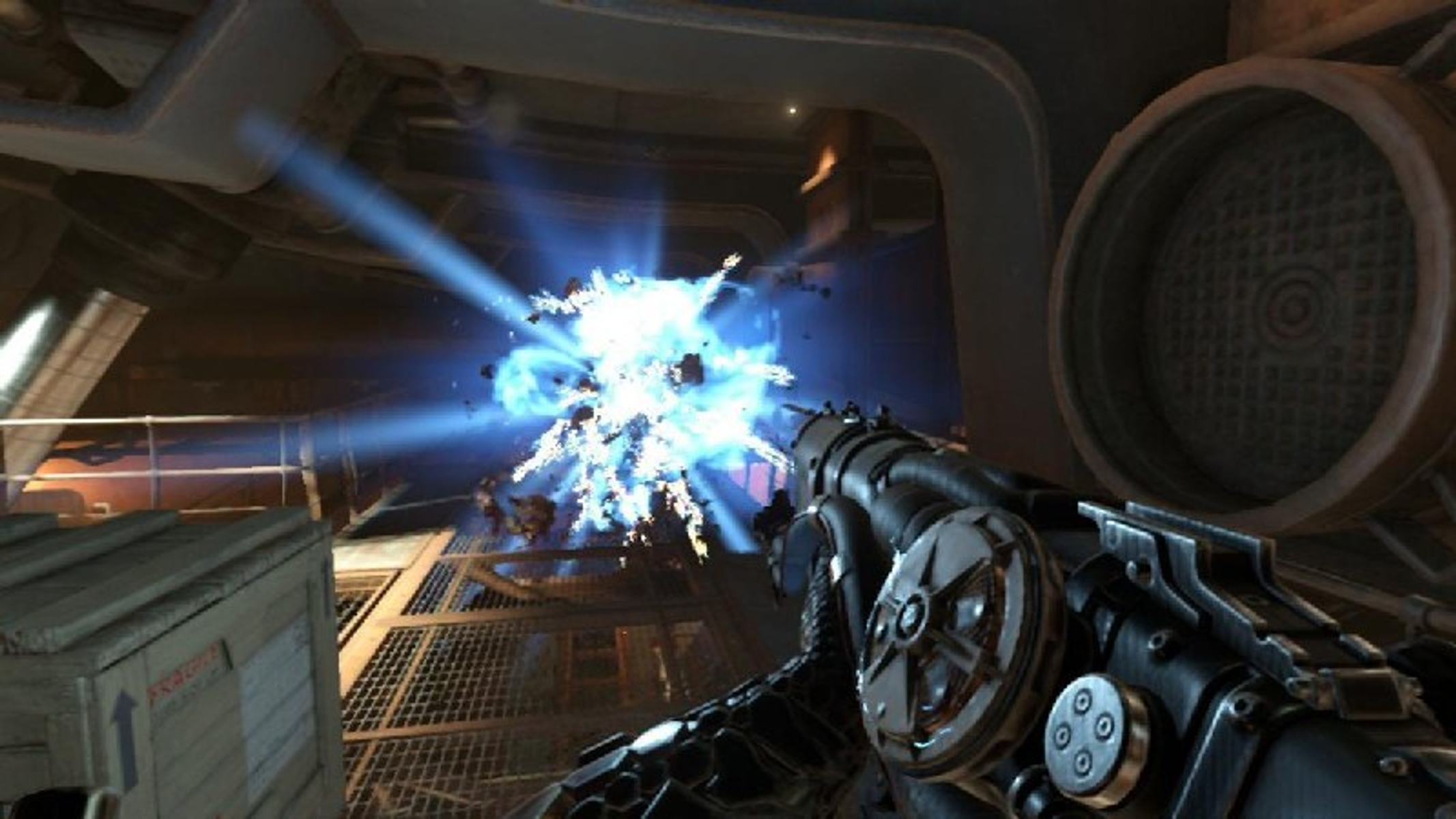 Scena di gioco, un'arma spara, con un'esplosione blu in un ambiente metallico.