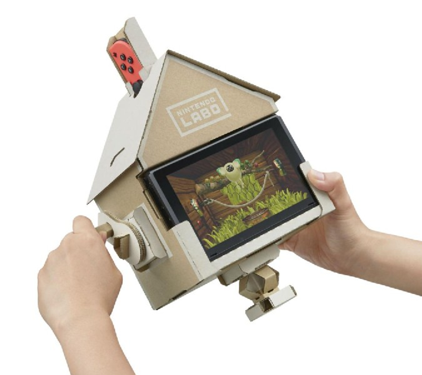 Eine Person hält ein Nintendo Labo-Set mit einem Bildschirm, der eine Spielszene mit einem Frosch zeigt.