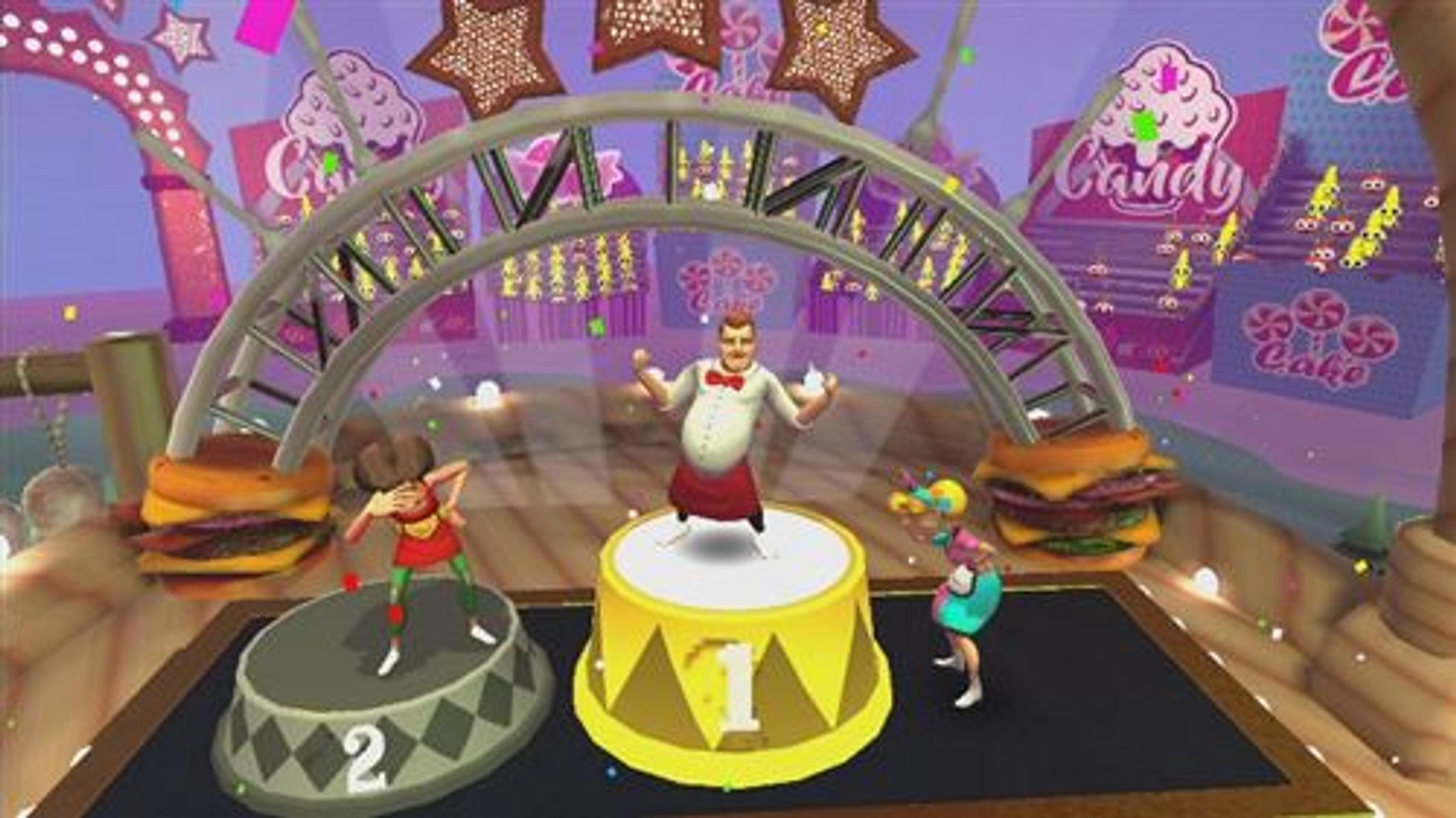 Spielszene mit Charakteren im Candy-Thema. Ein Mann auf der Bühne, zwei Tänzer und Burger als Requisiten.