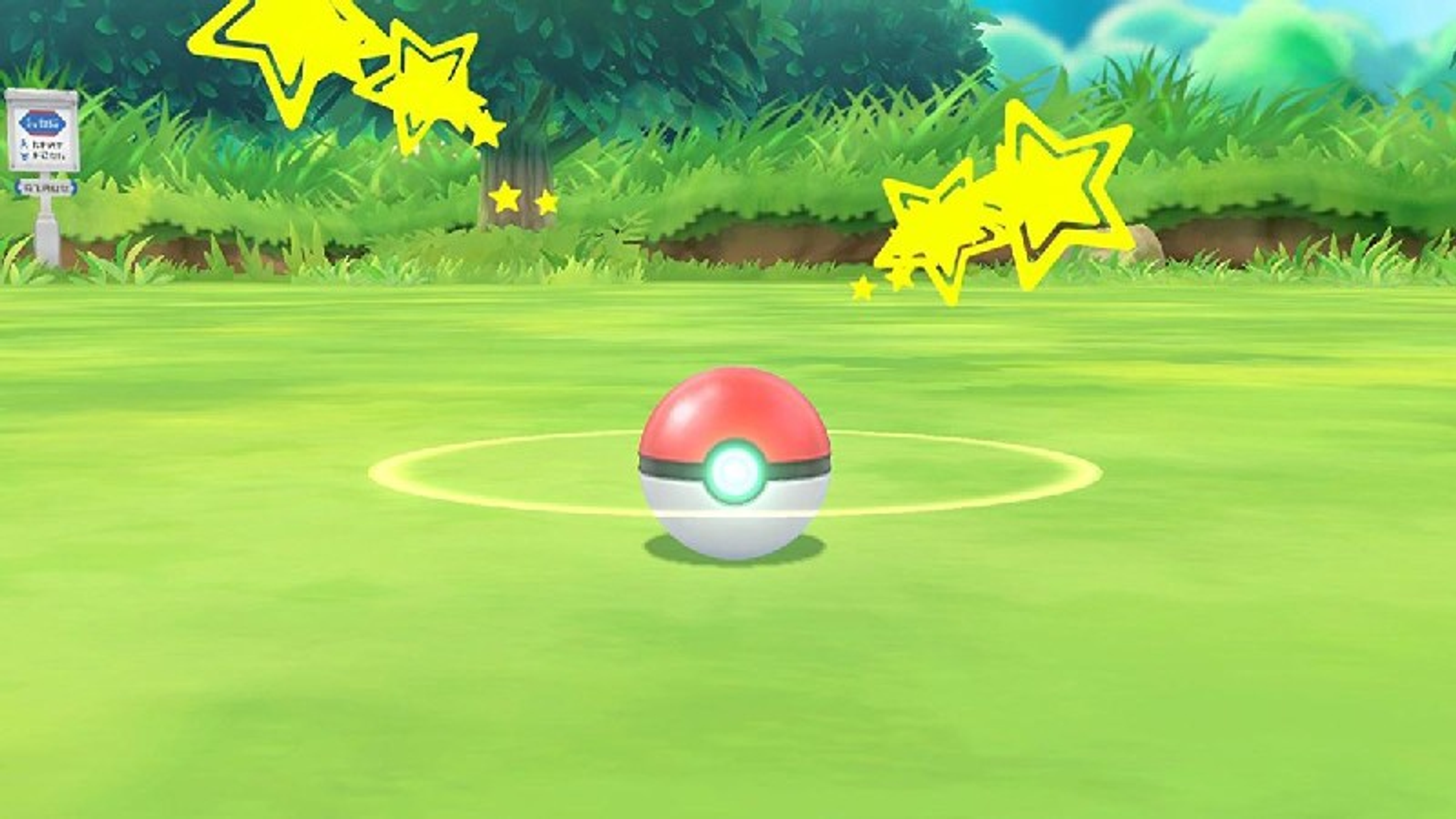 Czerwono-biała Pokéball na trawiastym polu z gwiazdami wokół.