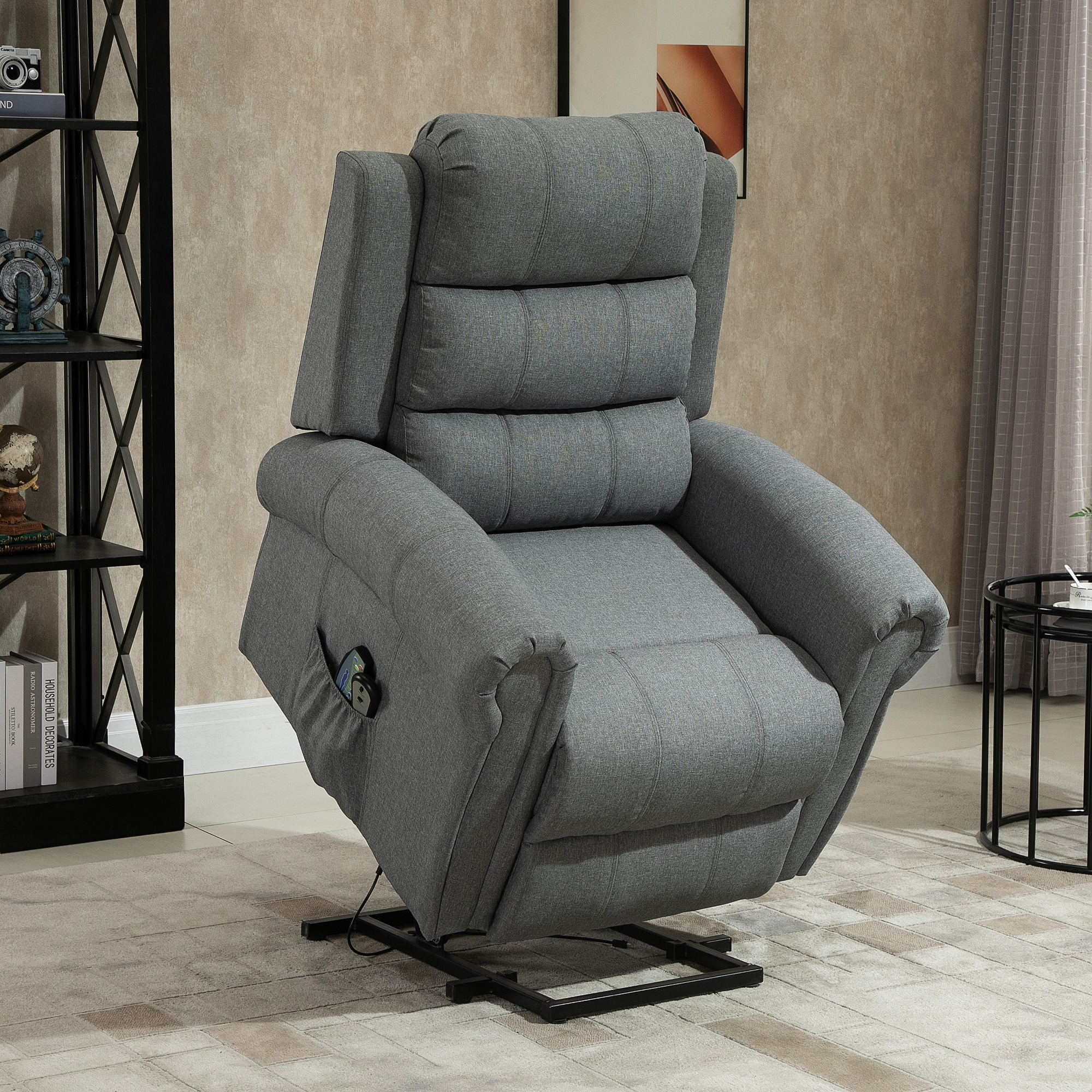 Sillón reclinable gris con reposapiés ajustable y mando en bolsillo lateral.