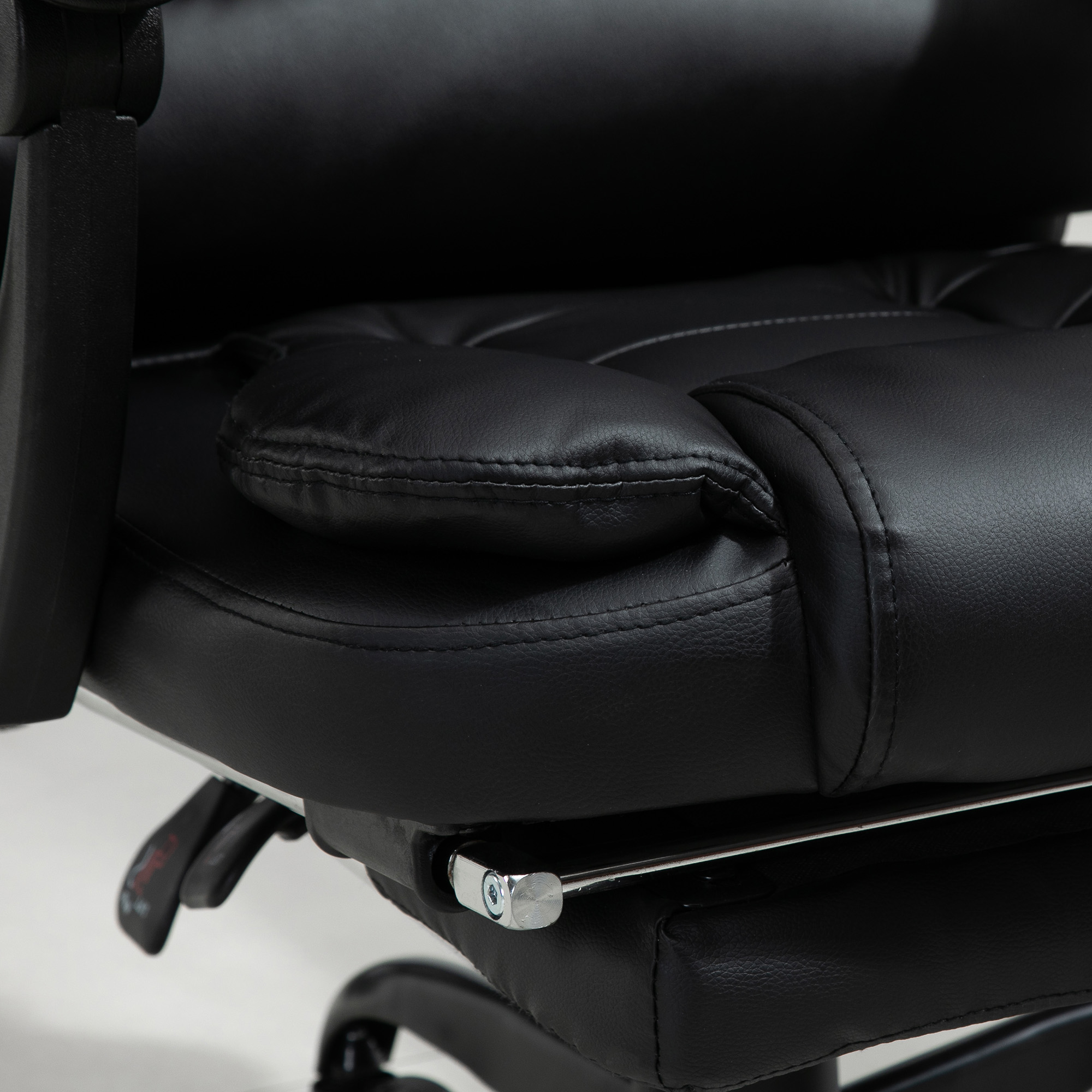 Primo piano di una sedia da ufficio nera. Mostra seduta, braccioli e parte della base. Tessuto in pelle visibile.