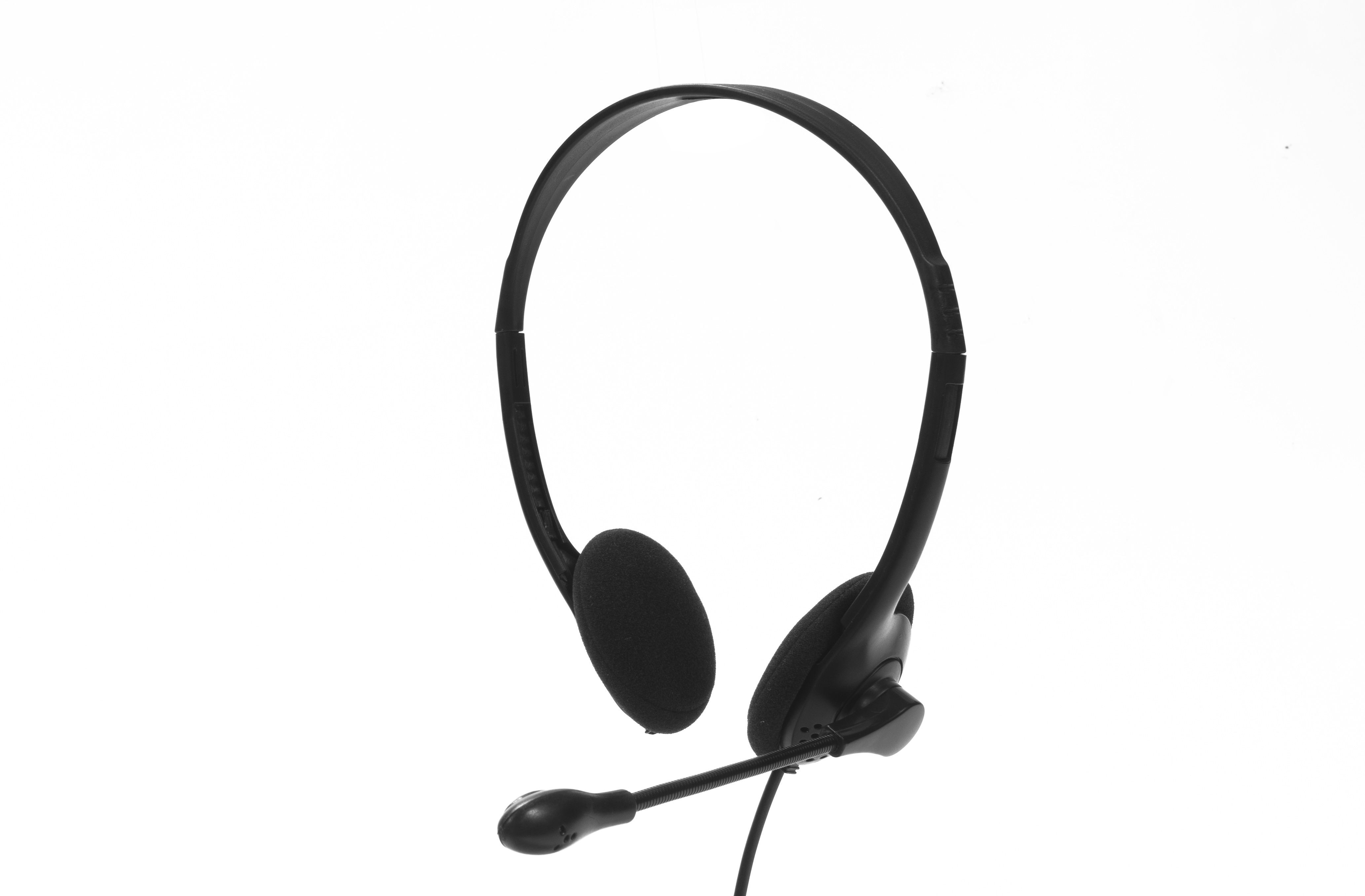 Auriculares negros con micrófono, sobre un fondo blanco.