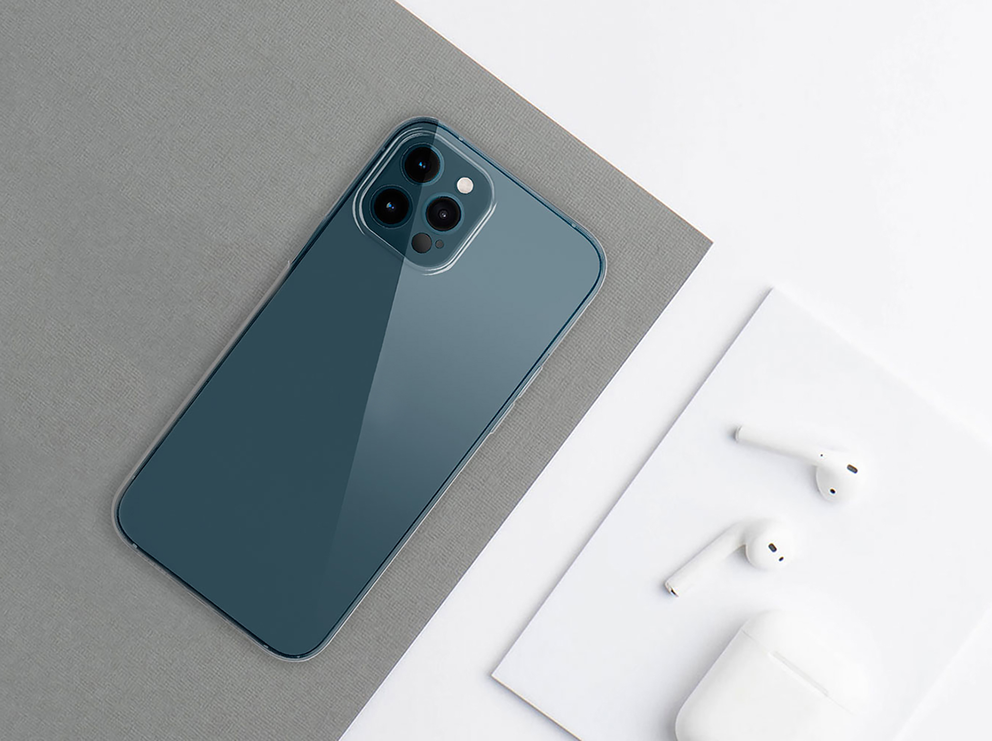 Draufsicht auf Telefon und AirPods auf grau-weißer Oberfläche.