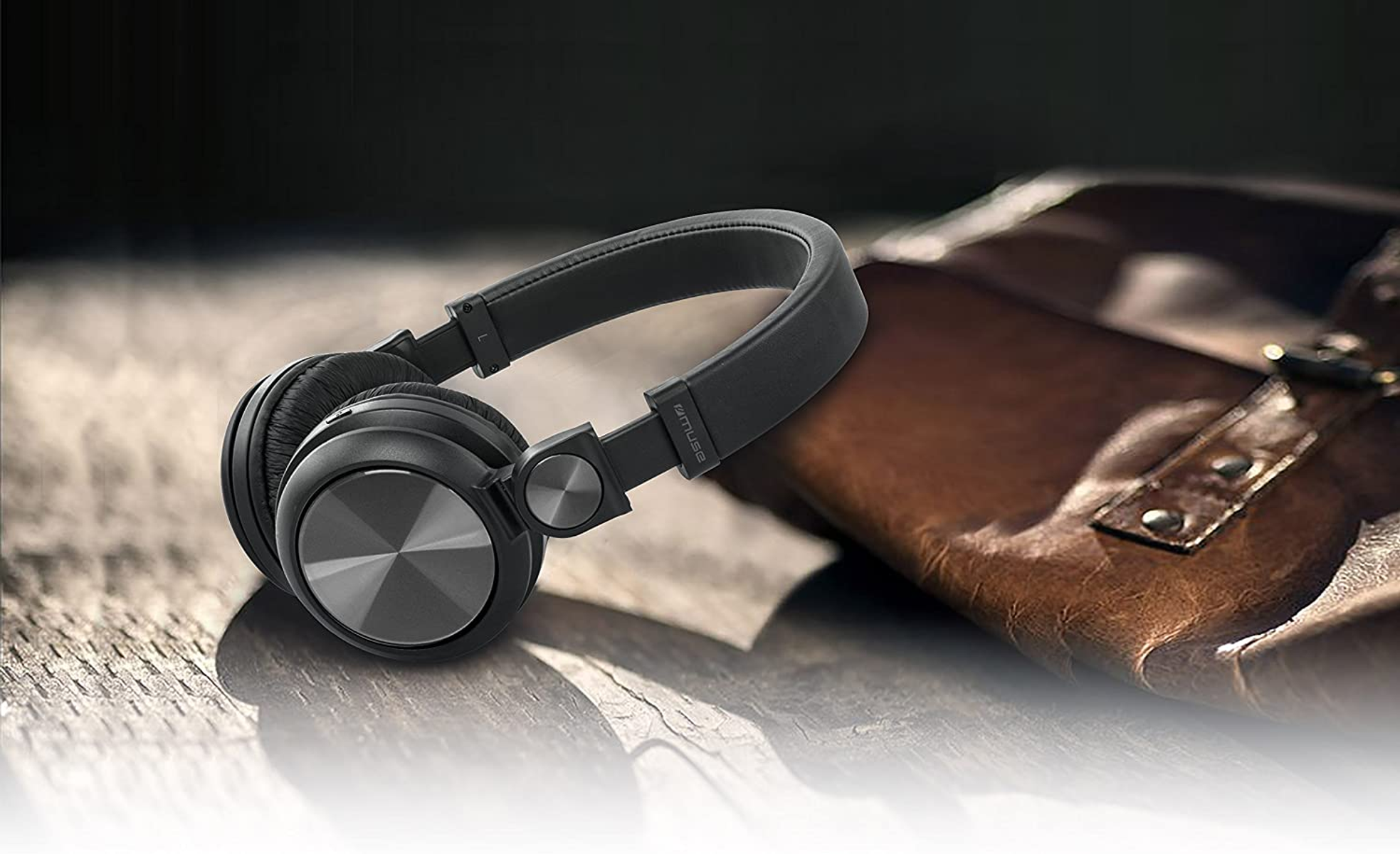 Czarne słuchawki ze srebrnymi akcentami spoczywające na drewnianej powierzchni.