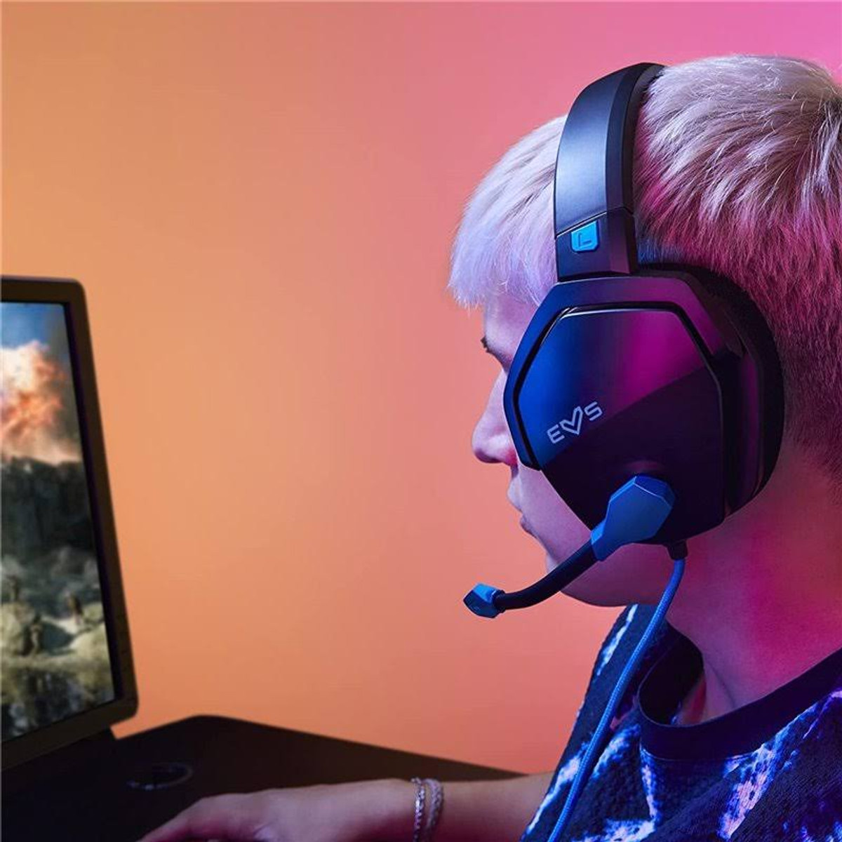 Persona usando unos auriculares para juegos. La persona está mirando una pantalla de ordenador.