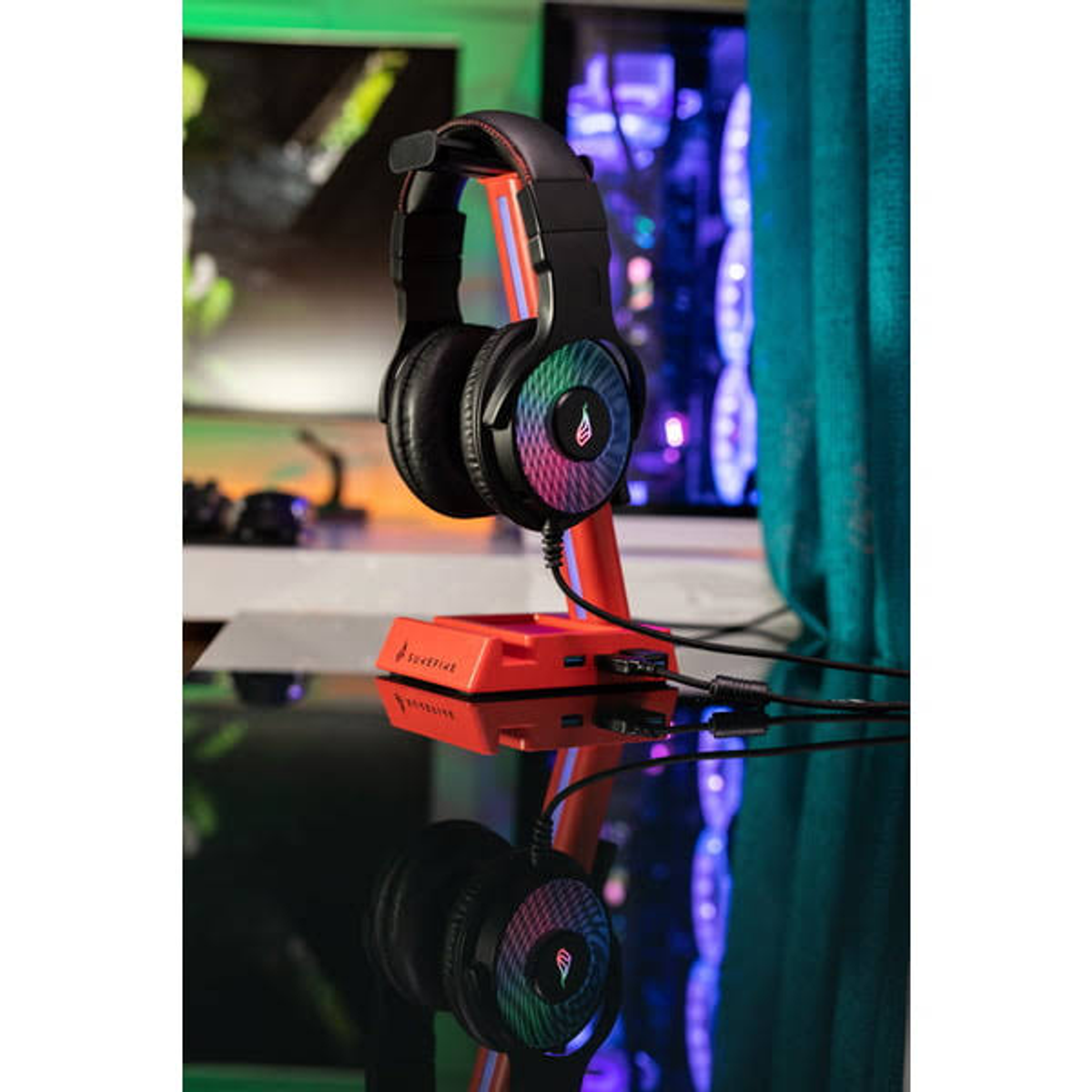 Auriculares gaming negros y rojos sobre un soporte. El soporte es rojo y los auriculares tienen detalles coloridos.
