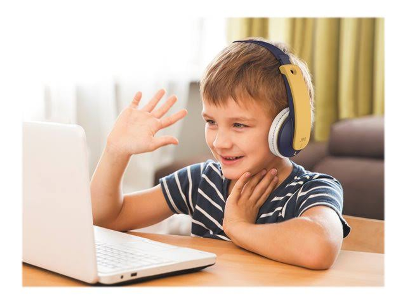 Un garçon avec un casque saluant devant un ordinateur portable.