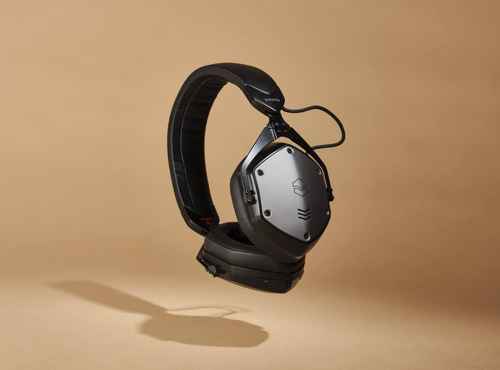 Casque noir flottant en l'air, incliné, avec un arrière-plan neutre.