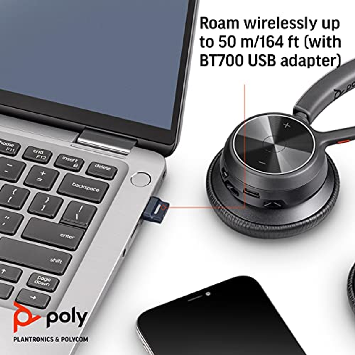 Casque à côté d'un ordinateur portable avec adaptateur USB. Téléphone en arrière-plan. Texte: Roaming sans fil jusqu'à 50 m.