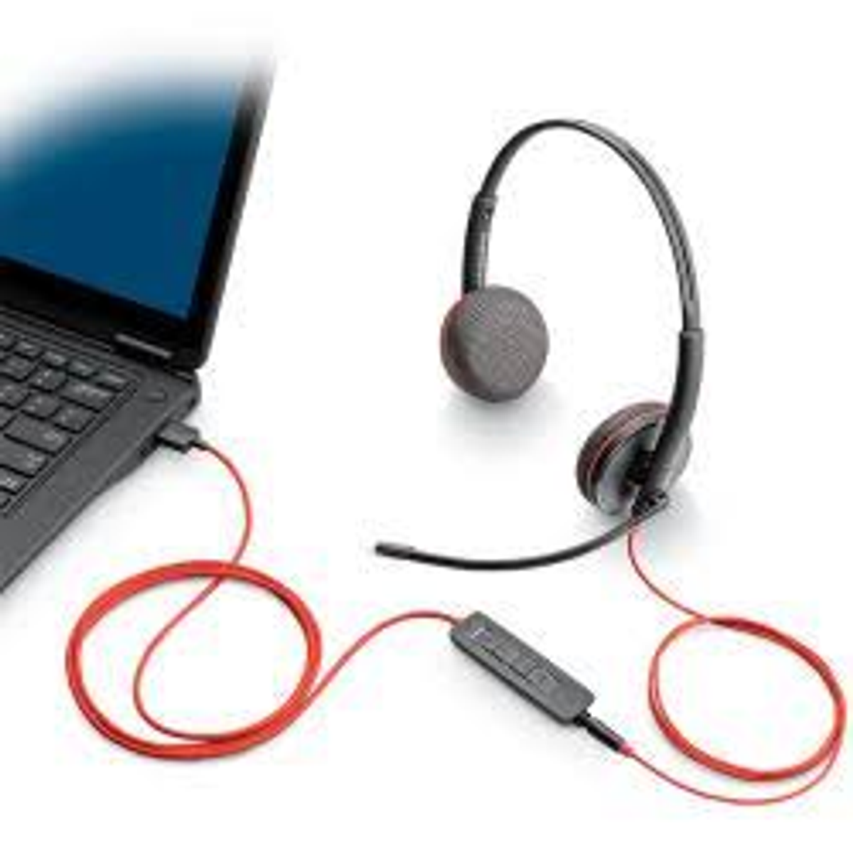 Een laptop verbonden met een rood bedrade headset met microfoon op een wit oppervlak.
