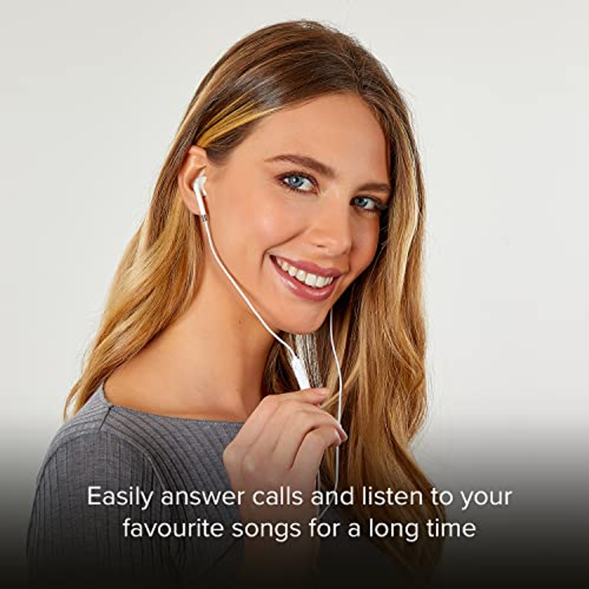Mujer sonriendo, con auriculares blancos. Fondo blanco.