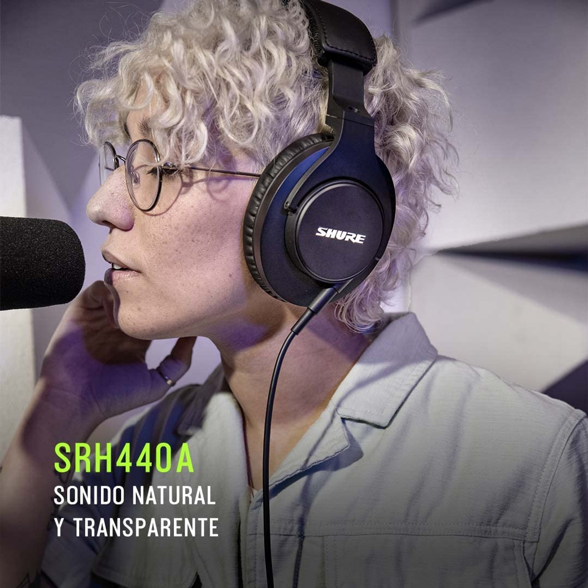 Osoba nosząca słuchawki. Słuchawki są czarne, z marką SHURE.