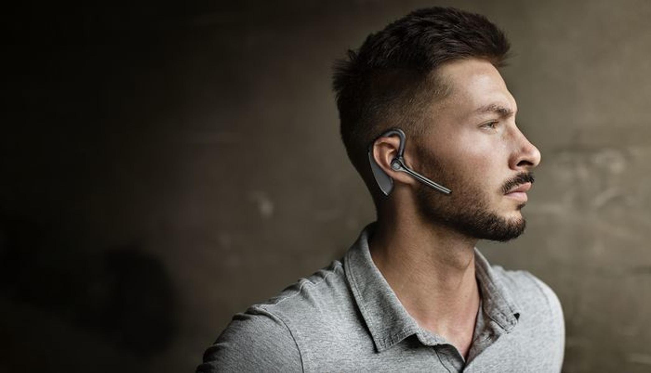 Ein Mann mit schwarzem Headset schaut nach rechts.