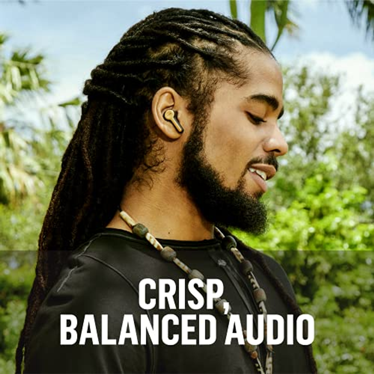 Mężczyzna z dredami w złotym słuchawce. Tekst: "CRISP, BALANCED AUDIO".