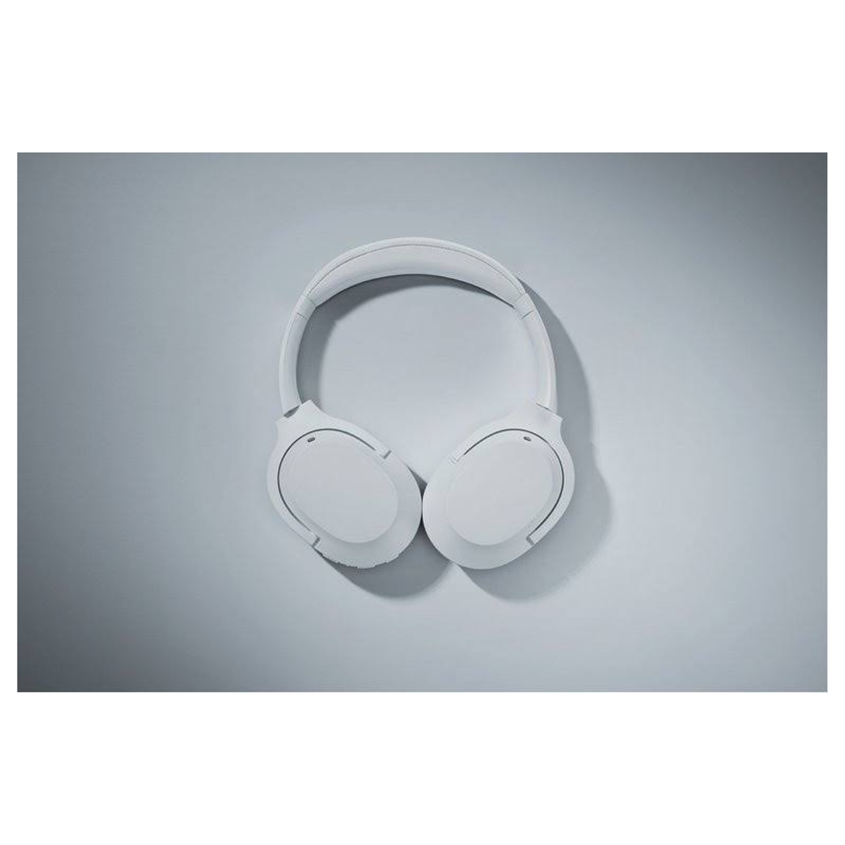 Białe słuchawki na szarym tle. Słuchawki z widoku z góry.