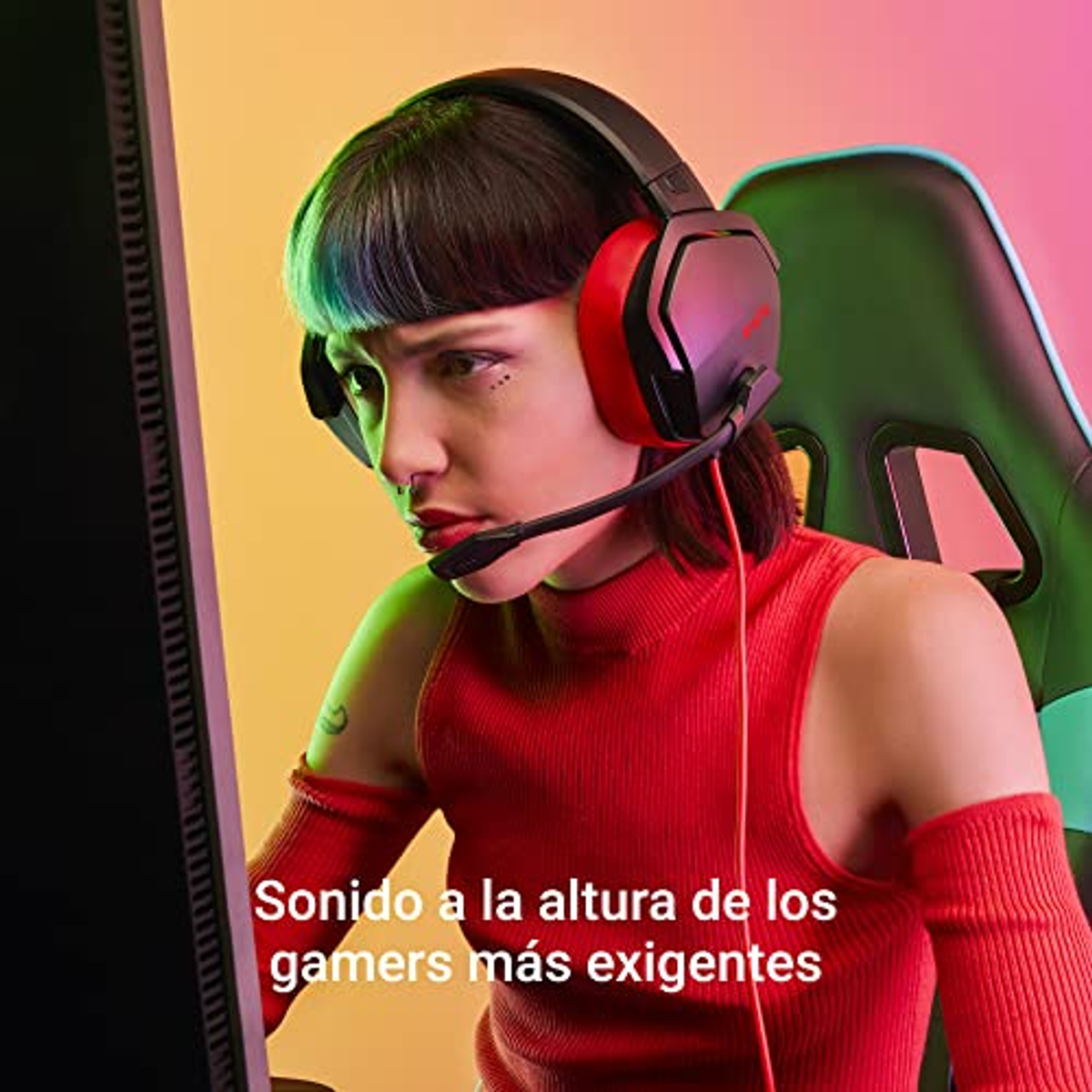 Kobieta w słuchawkach do gier patrzy na monitor. Monitor jest czarny, a tło kolorowe.