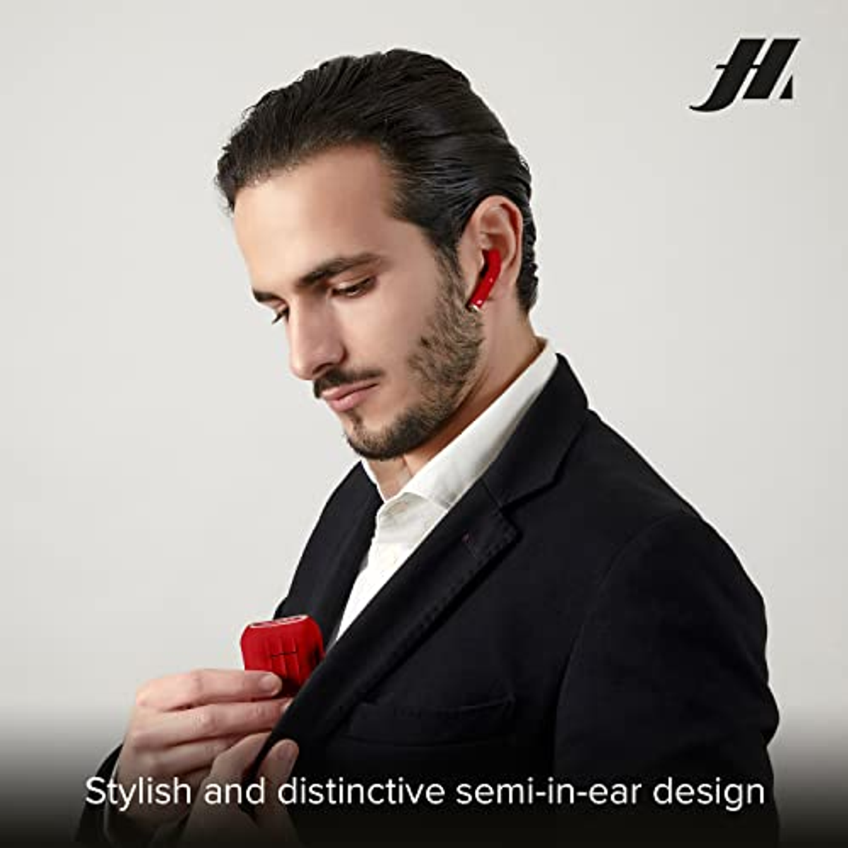 Mężczyzna w czarnym garniturze wkłada czerwone słuchawki do kieszeni. Tekst mówi o konstrukcji semi-in-ear.