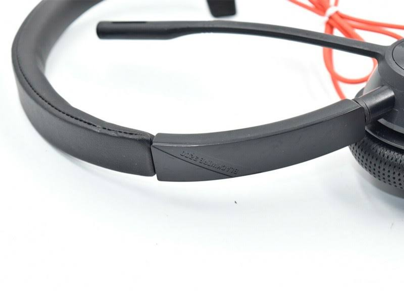 Zestaw słuchawkowy z czarnym pałąkiem i czerwonym kablem. Mikrofon jest po lewej stronie.