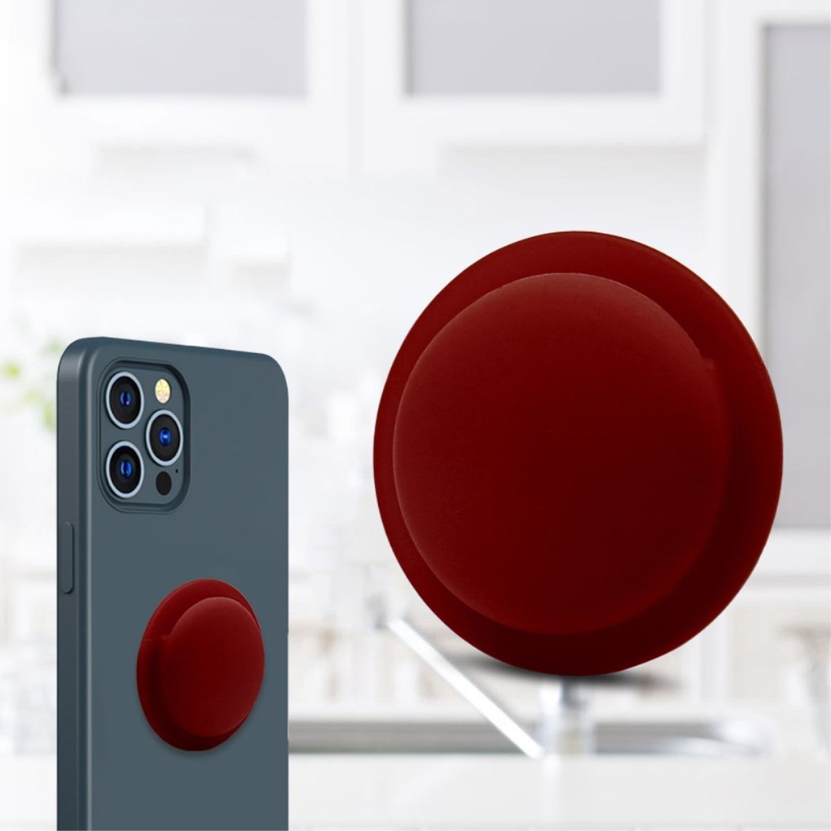 Eine Handyhülle mit rotem Pop-up-Griff. Das Telefon ist dunkelblau, im Hintergrund Küche.