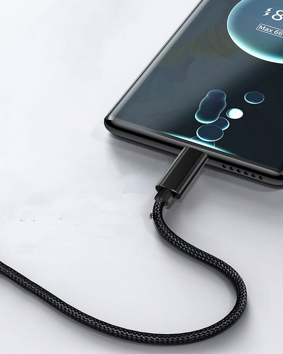 Czarny kabel ładujący jest podłączony do telefonu. Telefon jest ładowany. Telefon jest czarny.