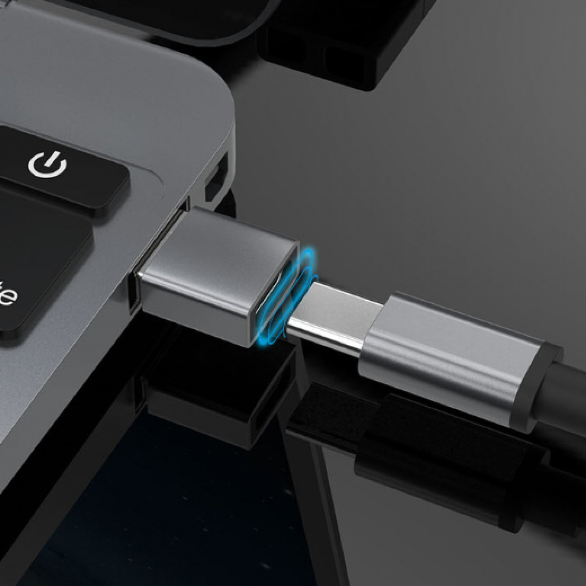Laptop podłączony do srebrnego adaptera USB-C. Adapter jest podłączony do laptopa.
