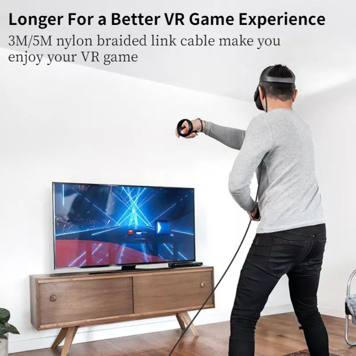 Mann mit VR-Headset hält Controller mit langem schwarzen Kabel, das mit einem Fernseher verbunden ist.