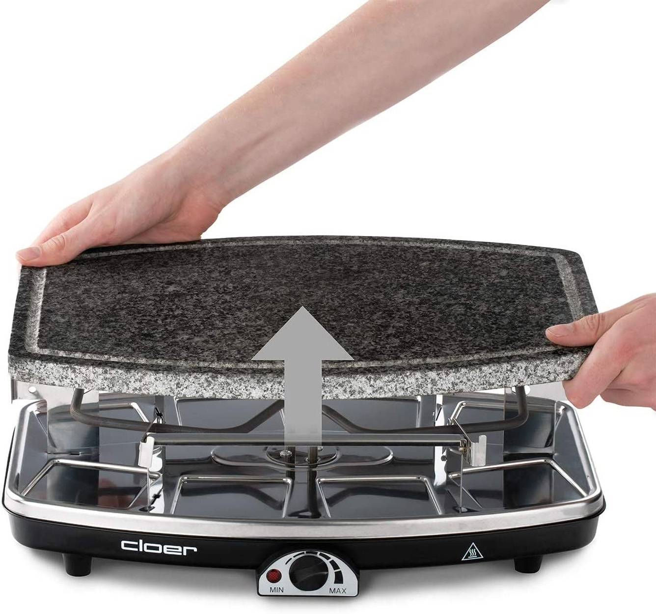 Hände entfernen einen Granitstein von einem Raclette-Grill. Ein schwarzes, elektrisches Gerät wird gezeigt.