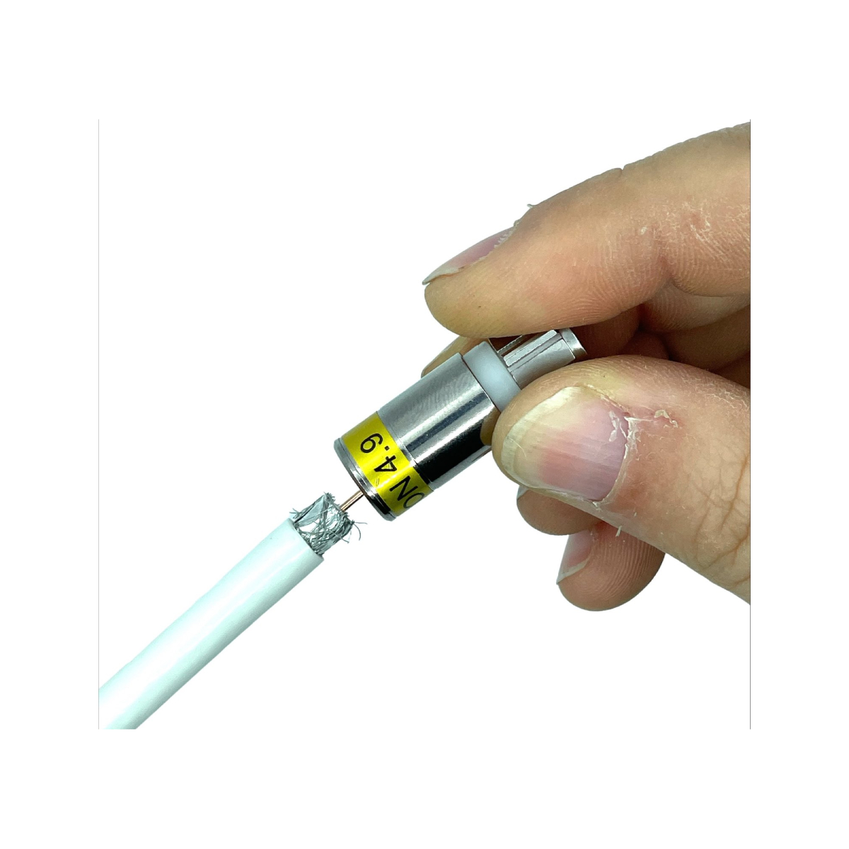 Eine Hand verbindet ein weißes Kabel mit einem silbernen Stecker, der mit 'DN 4.9' beschriftet ist, auf weißem Hintergrund.