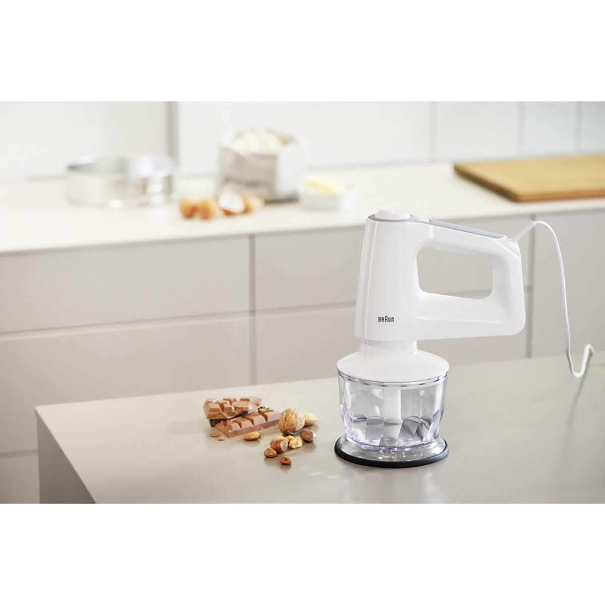 Witte handmixer met ingrediënten zoals noten en chocolade.