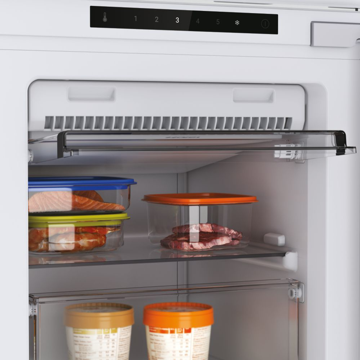 All'interno di un frigorifero bianco con ripiani. Ci sono contenitori con cibo all'interno del frigorifero.