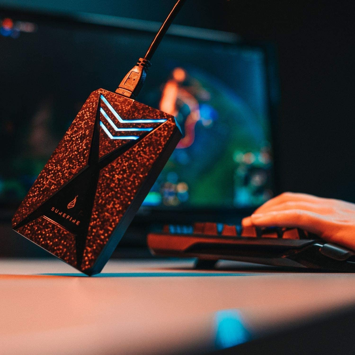 Przenośny dysk twardy ze światłami. Osoba używa klawiatury i myszy.