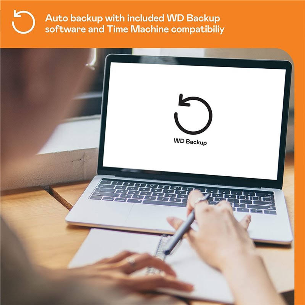 Laptop z logo WD Backup, z osobą piszącą na notatniku.