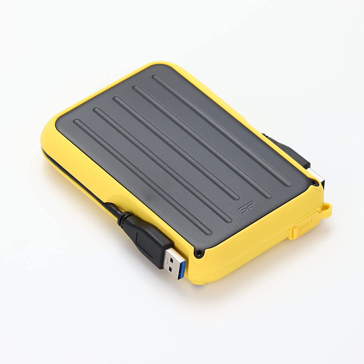 Disco rigido esterno giallo e grigio con un cavo USB collegato. È su una superficie bianca.