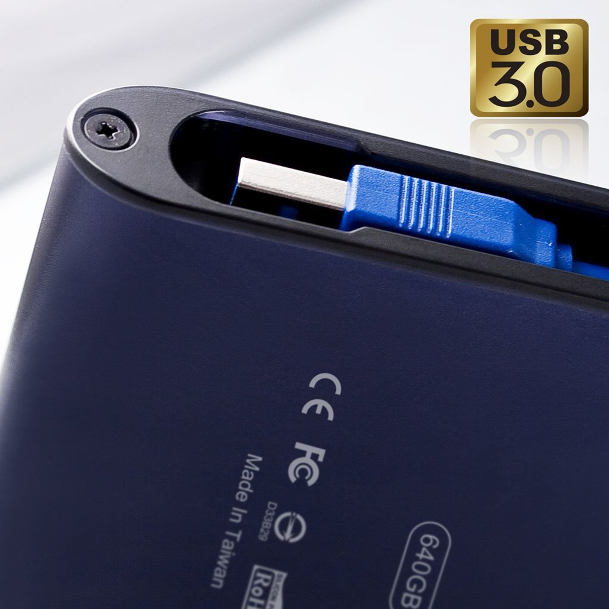 Primer plano de un disco duro externo azul oscuro con un cable USB azul enchufado. Etiqueta USB 3.0.