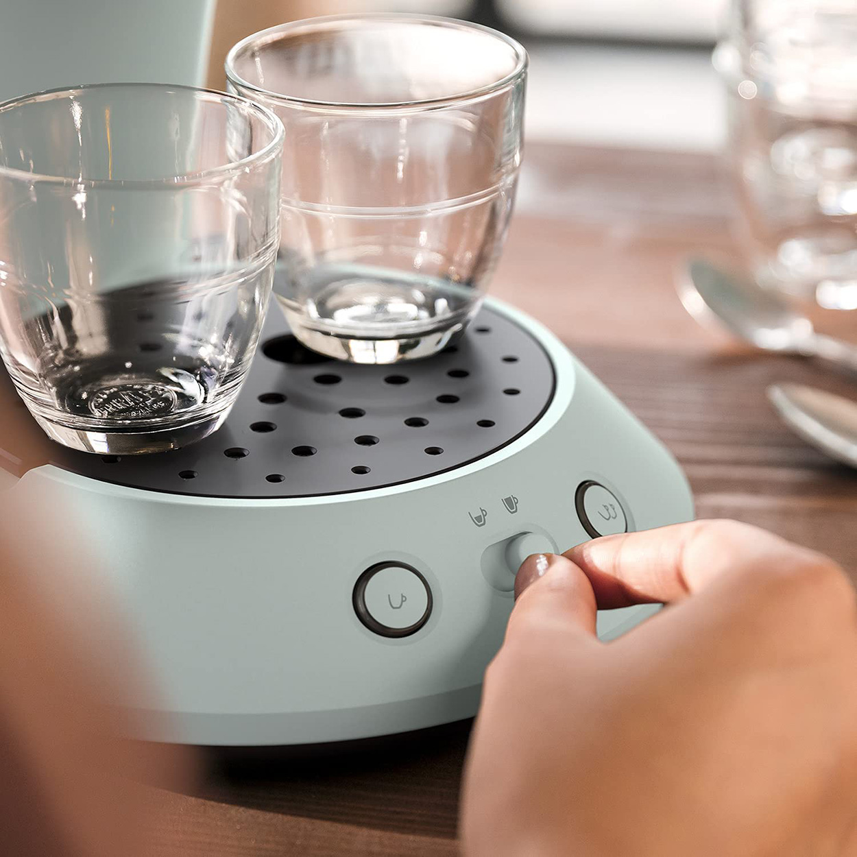 Die Hand einer Person, die eine Kaffeemaschine einstellt.