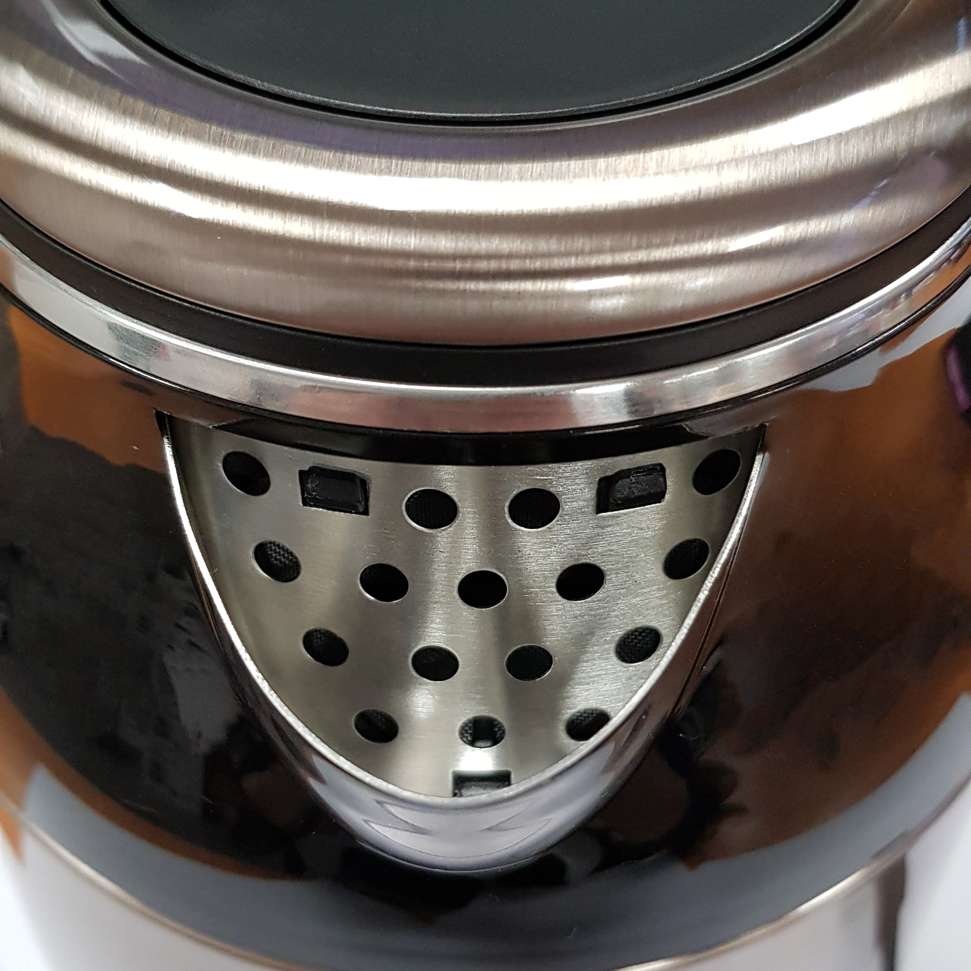 Zbliżenie wylewki czajnika ze stalową krawędzią i czarnym korpusem.