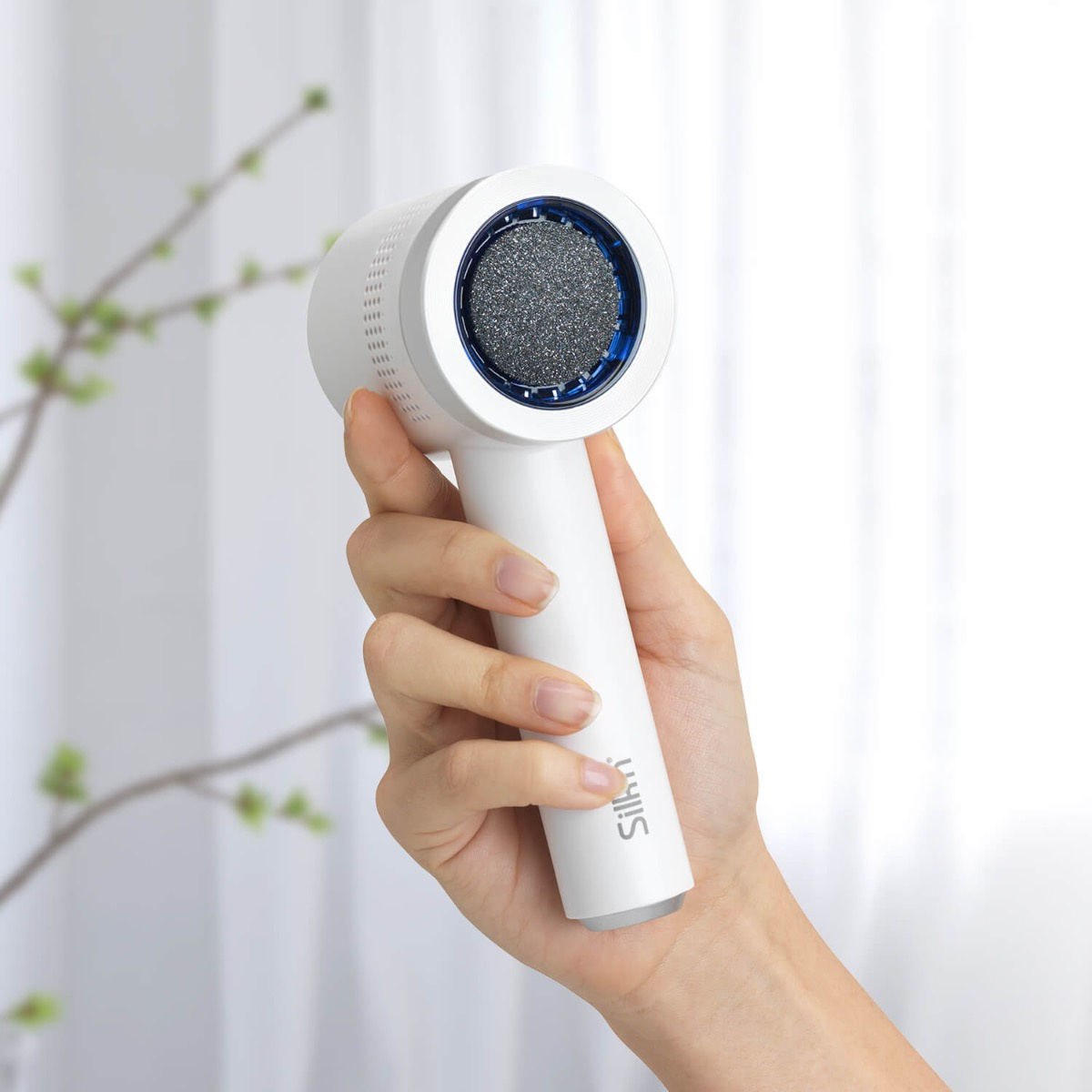 Biały pilnik do stóp jest trzymany przez dłoń na miękkim, rozmytym tle. Pilnik ma niebieski detal.