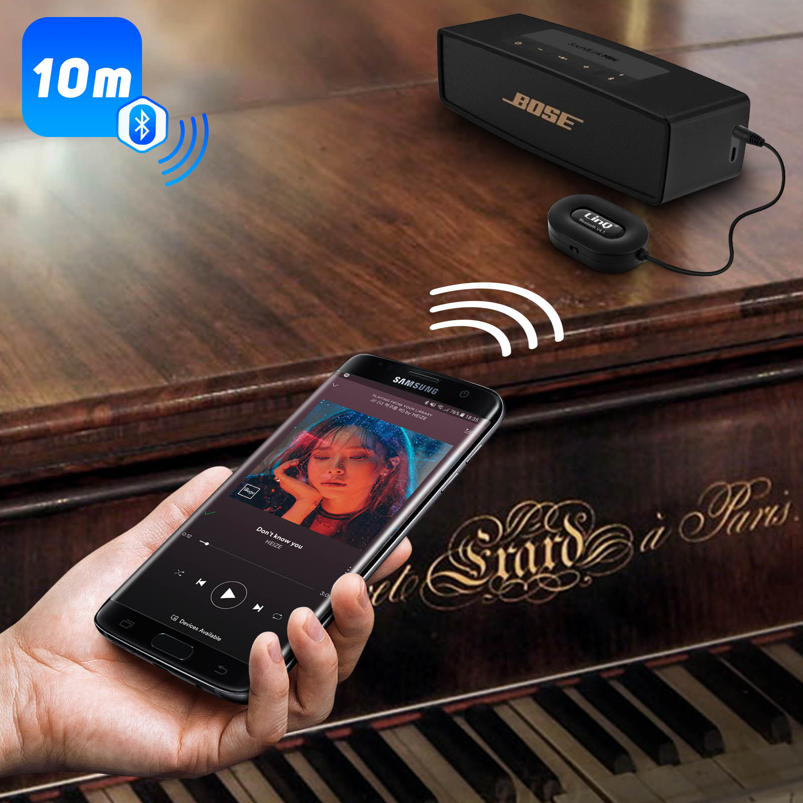 Una persona che tiene un telefono sta suonando musica su un pianoforte con un altoparlante vicino.