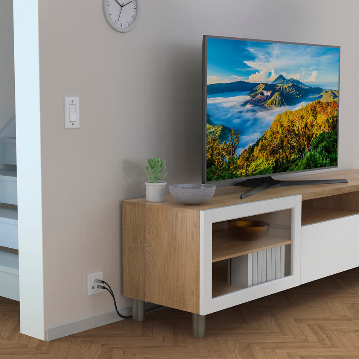 Salon z telewizorem, drewnianą szafką, włącznikiem ściennym i drewnianą podłogą.