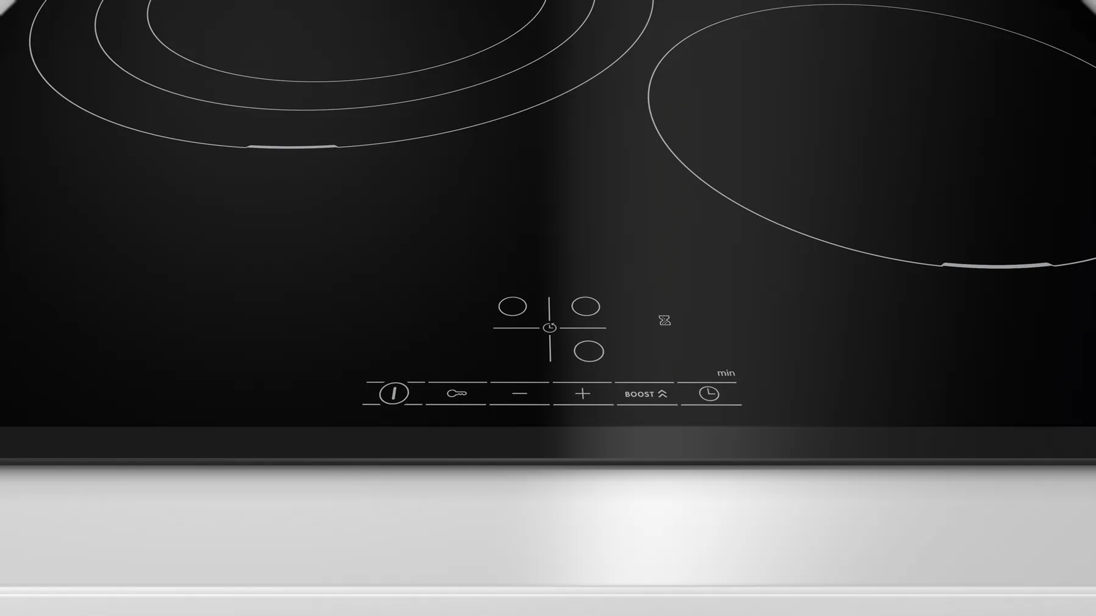 Czarna płyta indukcyjna z czterema okrągłymi palnikami i dotykowym sterowaniem. Zbliżenie.