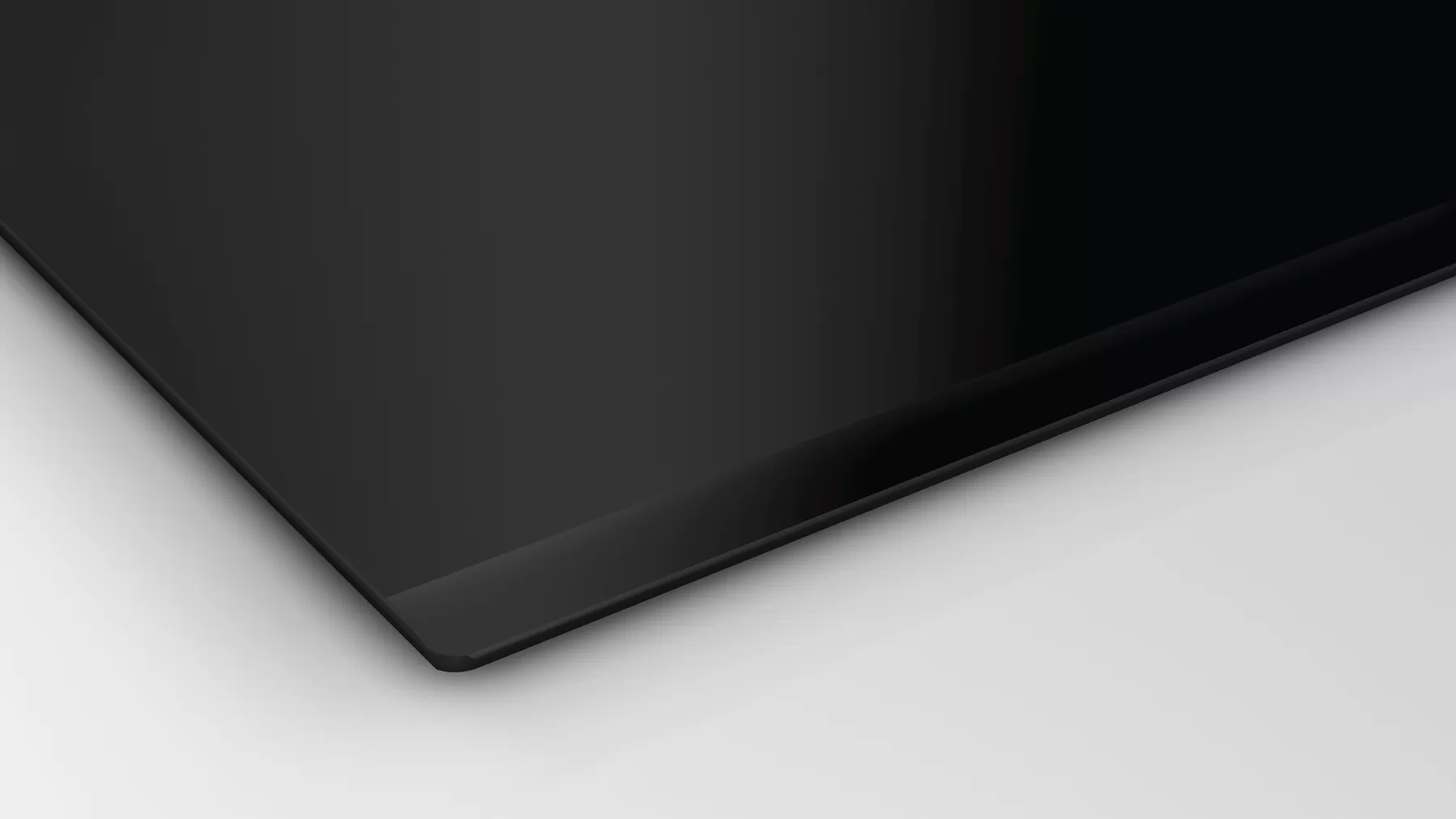 Czarna płyta ceramiczna, pod kątem, na białym tle.