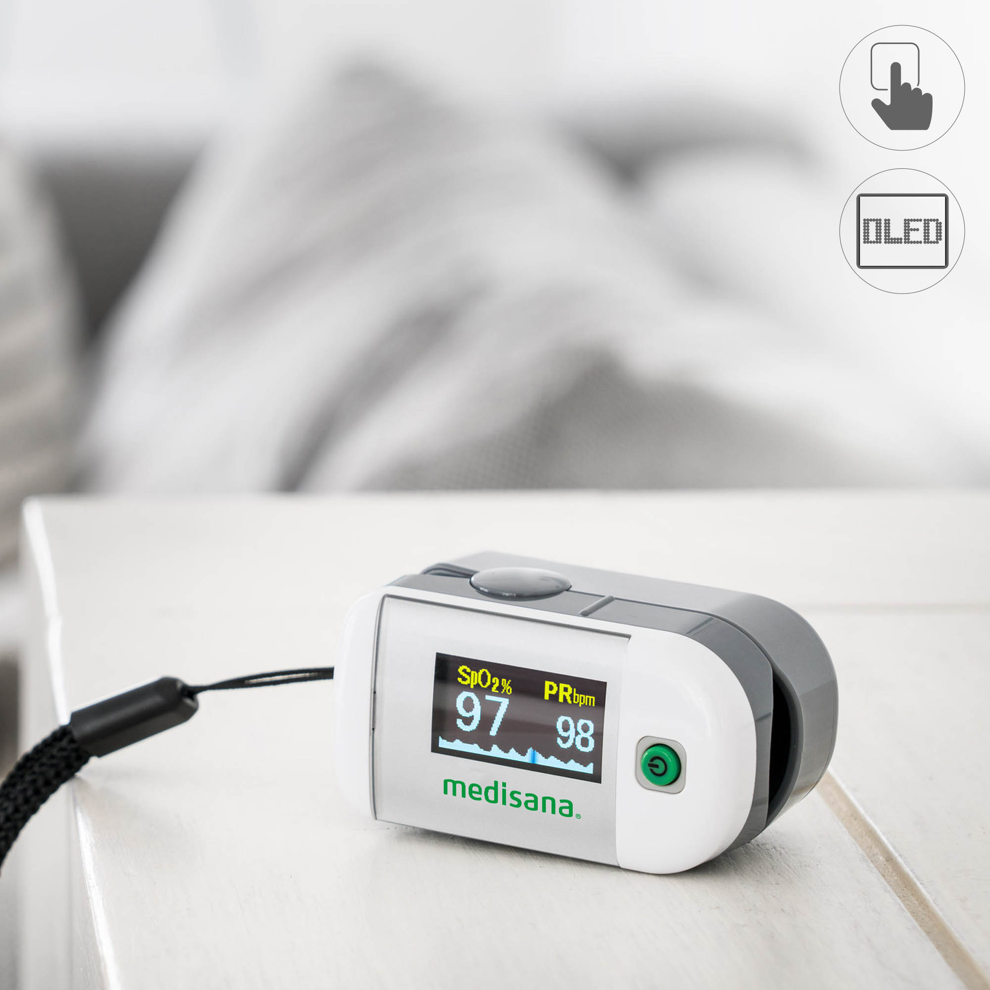 Weißes und graues Pulsoximeter zeigt SpO2 und Pulsfrequenz an. Auf weißer Oberfläche.