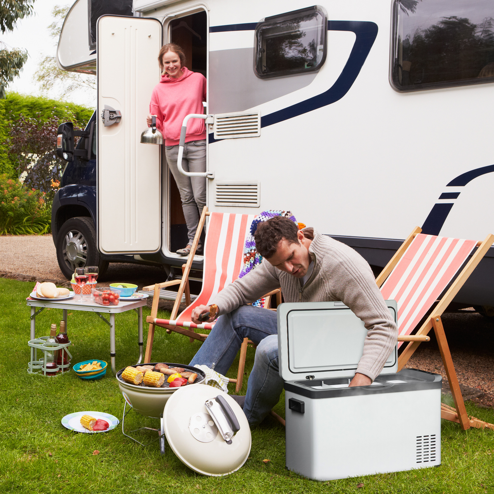 Leute, die draußen campen, kochen und sich in der Nähe eines Wohnmobils entspannen.