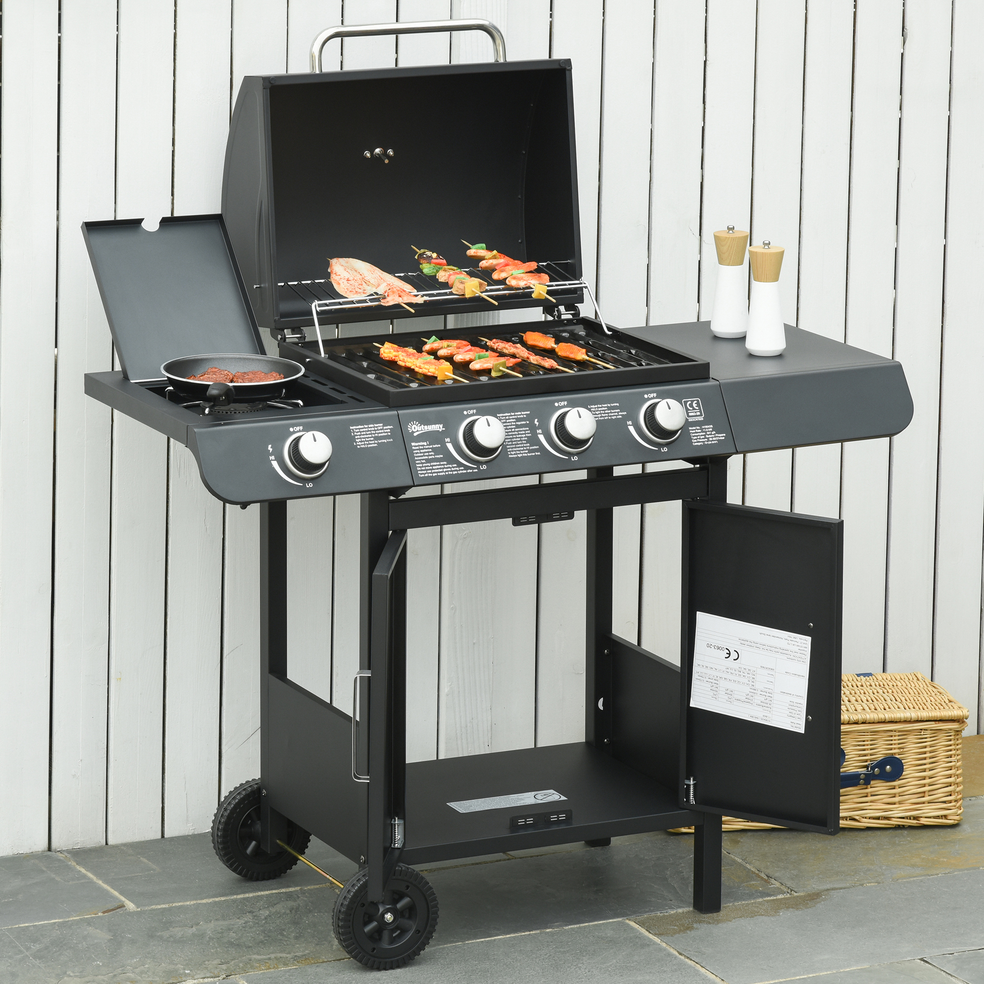 Un barbecue nero, aperto, con cibo che cuoce sulla griglia e sul fornello laterale. Sfondo bianco.