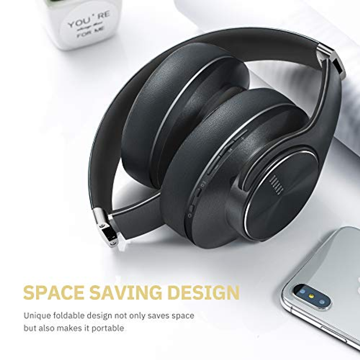 Auriculares negros plegados, con teléfono y texto: DISEÑO AHORRO ESPACIO.